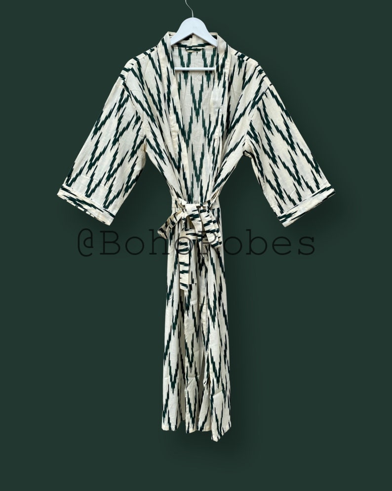 May include: A white and green patterned robe with a tie belt. The robe has a traditional kimono style with long sleeves and a relaxed fit.