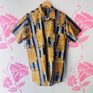 May include: A short-sleeved button-down shirt with a striped pattern and a tiger print. The shirt is blue, black, and yellow.