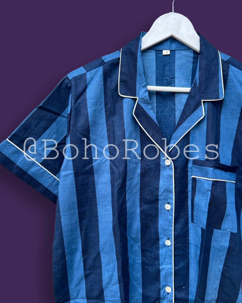 K&ouml;nnte beinhalten: Ein kurz&auml;rmeliges Hemd mit blau-wei&szlig;em Streifenmuster, wei&szlig;em Kragen und Knopfleiste. Das Hemd hat einen wei&szlig;en Besatz am Kragen und an den Manschetten.