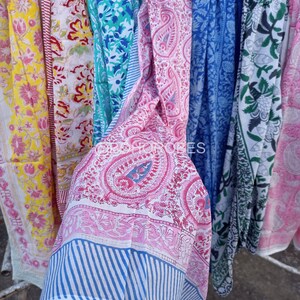 May include: A collection of colourful cotton fabric strips with various floral and paisley patterns. The fabric is white with pink, blue, green, and yellow accents.