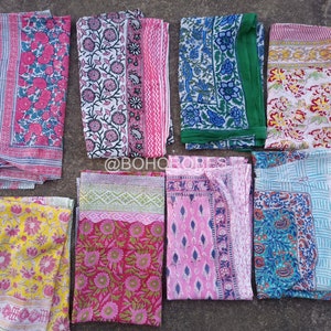 May include: Nine different patterned fabric squares in various colours, including pink, blue, green, yellow, and white. The fabric squares are arranged in a row on a grey surface.  @BOHO_ROBES