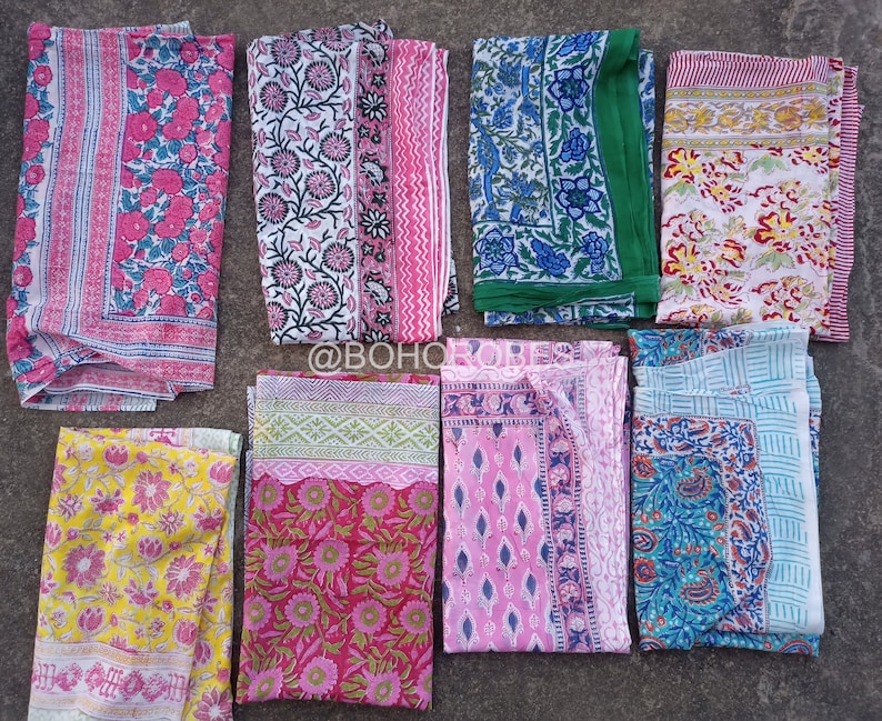 May include: Nine different patterned fabric squares in various colours, including pink, blue, green, yellow, and white. The fabric squares are arranged in a row on a grey surface.  @BOHO_ROBES