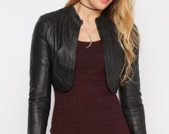 May include: A black cropped leather jacket with long sleeves. The jacket has a zipper closure and a stand-up collar.