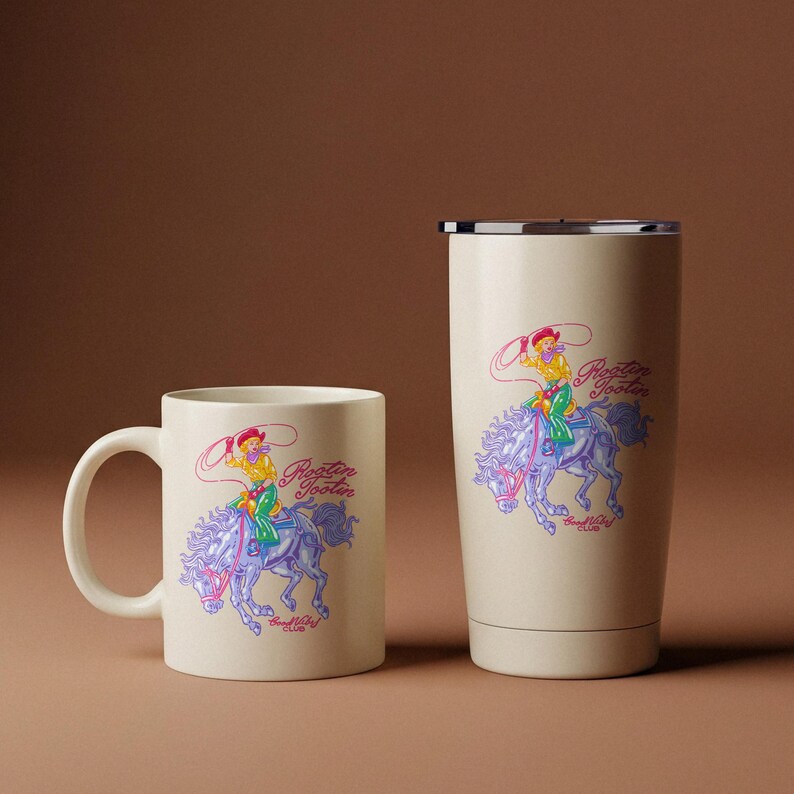 K&ouml;nnte beinhalten: Eine cremefarbene Kaffeetasse und ein Becher mit einem Cartoon-Cowboy, der mit einem Lasso auf einem Pferd reitet. Das Design enth&auml;lt den Text "Rootin' Tootin' Good Ol' Club" in einem farbenfrohen Vintage-Stil.
