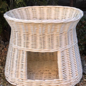 Peut inclure: Lit pour animal en osier blanc avec une ouverture ronde &agrave; l'avant. Le lit est fait d'osier tress&eacute; et a un aspect naturel et rustique.