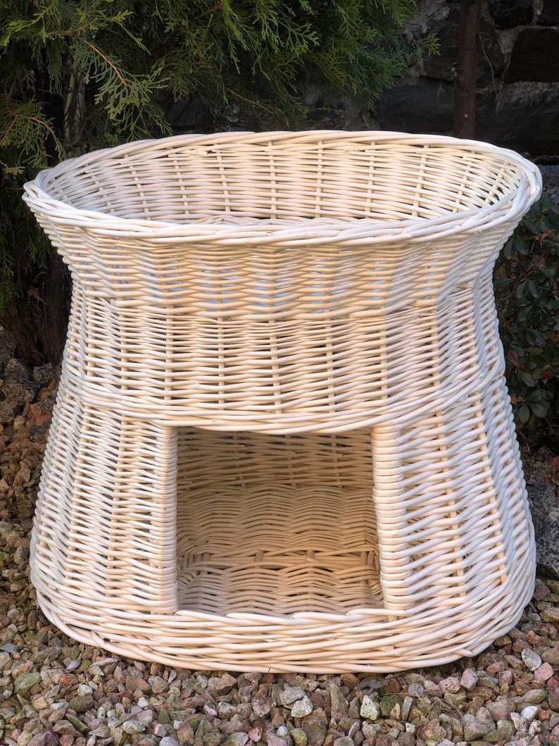 Peut inclure: Lit pour animal en osier blanc avec une ouverture ronde &agrave; l'avant. Le lit est fait d'osier tress&eacute; et a un aspect naturel et rustique.