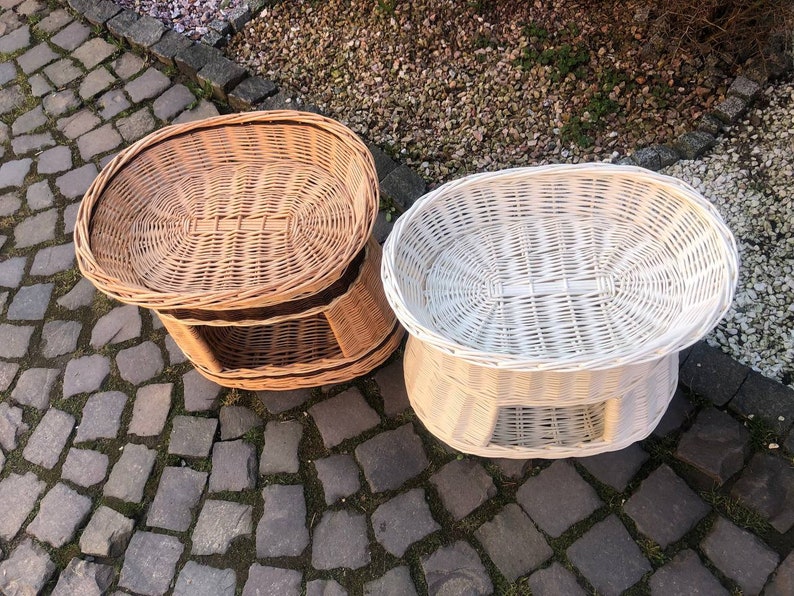 Peut inclure: Deux paniers en osier, l'un brun naturel et l'autre blanc, de forme ovale arrondie et avec une &eacute;tag&egrave;re inf&eacute;rieure. Les paniers sont pos&eacute;s sur un patio en pierre.