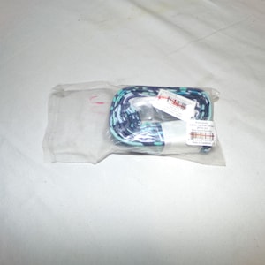 以下が含まれることがあります： 青、白、ターコイズブルーの模様のストラップが透明なビニール袋の中に巻かれています。 ストラップは織り込まれた素材でできているようです。 テキストとバーコードが付いた白いタグがストラップに付いています。