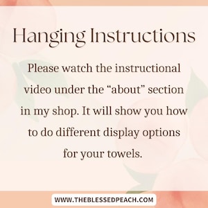Op de afbeelding: Een perzikkleurige achtergrond met een wit rechthoek met tekst die luidt "Hanging Instructions" en "Kijk de instructievideo onder de "about" sectie in mijn winkel. Het laat je zien hoe je verschillende weergaveopties voor je handdoeken kunt maken." De tekst bevat ook het websiteadres "www.theblessedpeach.com".