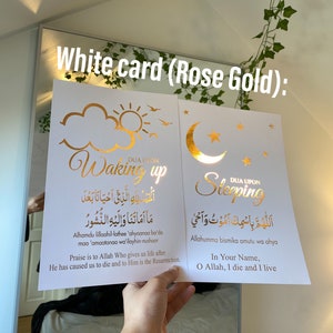 Puede incluir: Dos tarjetas blancas con letras doradas. La primera tarjeta tiene un sol y nubes con el texto "DUA UPON Waking up" y una frase árabe. La segunda tarjeta tiene una luna creciente y una estrella con el texto "DUA UPON Sleeping" y una frase árabe.