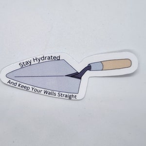 May include: A sticker featuring a trowel illustration. The trowel is gray with a black handle and a light brown wooden handle. Text on the sticker reads "Stay Hydrated And Keep Your Walls Straight."