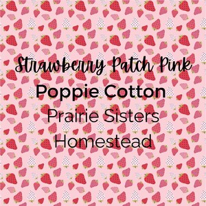May include: A pink fabric with a repeating pattern of red and white strawberries. The text "Strawberry Patch Pink Poppie Cotton Prairie Sisters Homestead" is overlaid on the fabric.