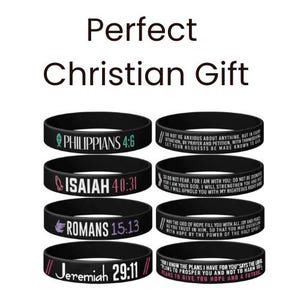 May include: Black rubber wristbands with white text featuring Bible verses. The image includes the text "Perfect Christian Gift" at the top. Verses include Philippians 4:6, Isaiah 40:31, Romans 15:13, and Jeremiah 29:11.