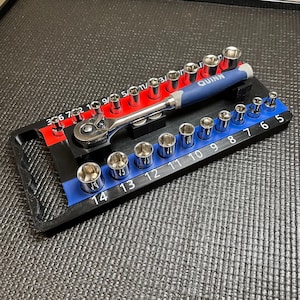 May include: A Quinn brand ratchet tool with a blue handle and a set of silver metal sockets organized on a black plastic tray. The tray features red and blue sections with printed numerical labels for socket sizes, including 5 through 14.