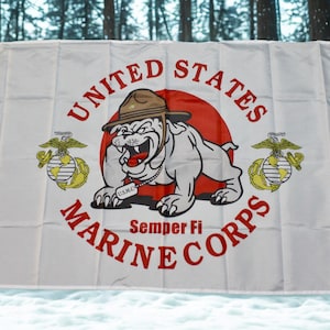 May include: White flag featuring the United States Marine Corps emblem. The design includes a bulldog wearing a hat, the words "United States Marine Corps" in red, and the motto "Semper Fi". Two emblems flank the bulldog.
