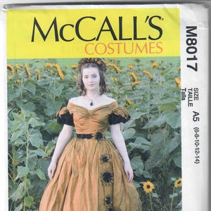 May include: A McCall's Costumes sewing pattern for a brown dress with black lace trim and sunflower embellishments. The pattern is for size A5 (6-8-10-12-14).