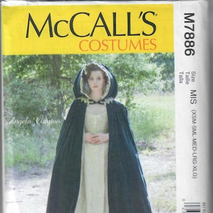 May include: McCall's Costumes sewing pattern M7886 for a hooded cape in green velvet with a white lace trim. The pattern is for sizes X-Small to X-Large.