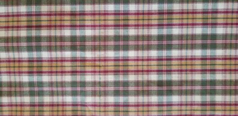 May include: A plaid fabric with a pattern of red, green, brown, and white stripes.