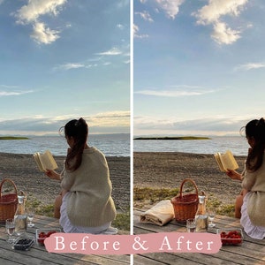 May include: A woman sits on a wooden dock by a lake, reading a book. She has a picnic basket, wine glasses, and fruit beside her. The sky is blue with white clouds.