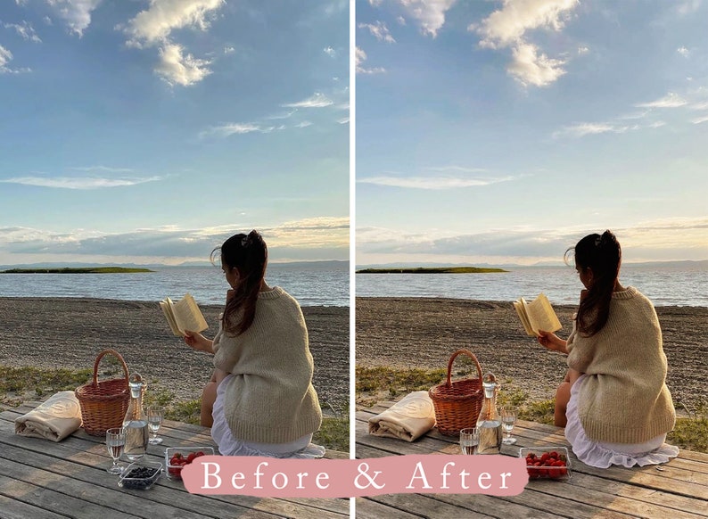 May include: A woman sits on a wooden dock by a lake, reading a book. She has a picnic basket, wine glasses, and fruit beside her. The sky is blue with white clouds.