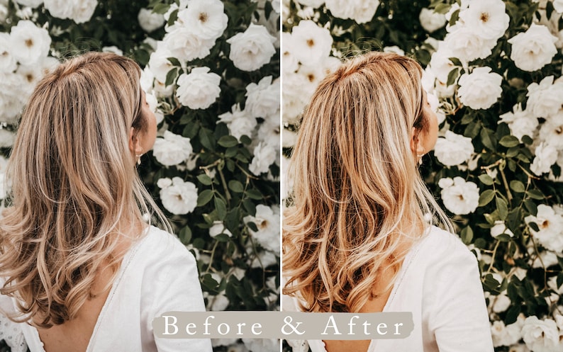 May include: A side view of a person with long, wavy, light brown hair standing in front of a wall of white flowers. The person is wearing a white, sleeveless top.