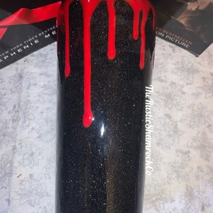 Pu&ograve; includere: Un bicchiere nero glitterato con un design di vernice rossa gocciolante. Il bicchiere ha una finitura lucida e il testo "The Rustic Shamrock Co" &egrave; visibile sul lato. Il bicchiere &egrave; cilindrico.