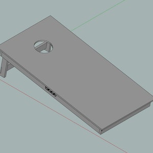 Può includere: Un tabellone da cornhole in legno grigio con un foro circolare al centro. Il tabellone è inclinato e ha una struttura di supporto in legno.