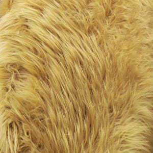 Puede incluir: Primer plano de una tela de piel sintética de color amarillo dorado. Las largas fibras desgreñadas crean una superficie texturizada. La tela tiene un aspecto cálido y acogedor, adecuada para diversos proyectos de artesanía y diseño.