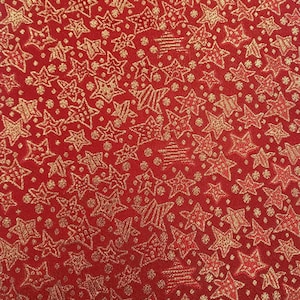 May include: Red fabric with a gold glitter pattern of stars. The stars are of various sizes and shapes.