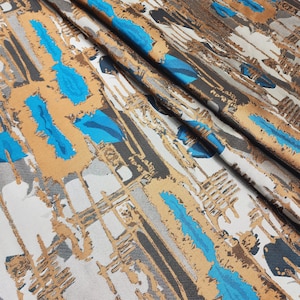 Puede incluir: Tela abstracta con un diseño tejido texturizado. La tela presenta un patrón de líneas y formas azules, marrones y grises.