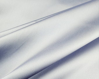 May include: A smooth, light blue fabric with a subtle sheen. The fabric is draped and folded, creating soft curves and folds.