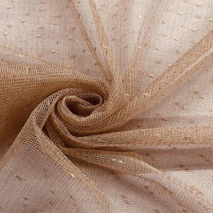 Puede incluir: Primer plano de una tela beige transparente con un delicado estampado de puntos. La tela está drapeada y doblada, creando un efecto texturizado. Pequeñas motas doradas están dispersas por el material, añadiendo un brillo sutil.