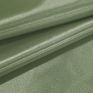 May include: Close-up of olive green fabric with a subtle sheen. The fabric is folded, creating soft shadows and highlights. The texture appears smooth and possibly silky, suggesting a luxurious material.