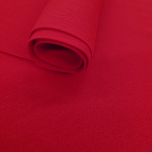 May include: A roll of bright red felt fabric. The felt is tightly rolled, revealing the texture and color of the material. The fabric is a solid, vibrant red, suitable for various craft projects.