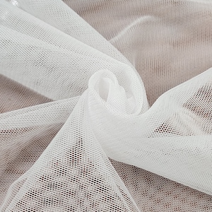 Puede incluir: Tela de tul blanco con una textura de malla fina. La tela es suave y delicada, y es perfecta para manualidades y decoración.