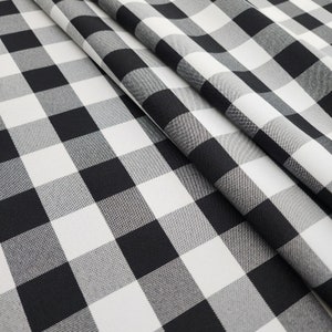 May include: Black and white checkered fabric with a large square pattern. The fabric is folded in half, showing the pattern on both sides.