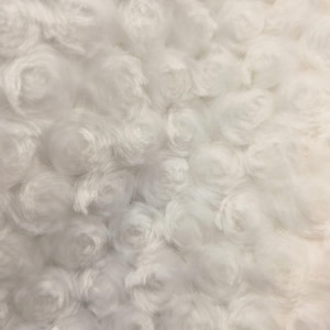 Puede incluir: Primer plano de una tela blanca texturizada con un patrón de formas arremolinadas en forma de rosa. El material suave y esponjoso tiene una apariencia densa y tridimensional. Ideal para la decoración del hogar o proyectos de manualidades.
