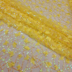 Può includere: Tessuto giallo con un motivo a farfalla e paillettes. Il tessuto è trasparente e ha una texture delicata.