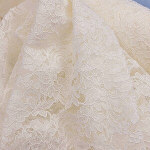 May include: White lace fabric with a delicate floral pattern.