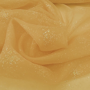 Puede incluir: Una tela de tul de color naranja claro transparente con un acabado de purpurina fina y dispersa. El material está drapeado en pliegues suaves y fluidos, destacando la calidad translúcida de la malla y las partículas brillantes reflectantes.