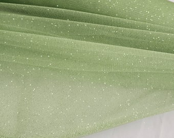 May include: A pale green tulle fabric with a subtle sparkle. The fabric is soft and sheer, and it has a delicate texture.