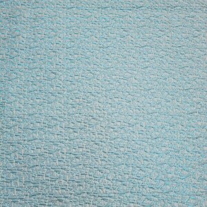 May include: A close-up of a light blue textured fabric with a woven pattern.