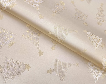 Può includere: Tessuto color crema con un motivo ripetuto di alberi di Natale dorati. Il tessuto ha una leggera lucentezza e una texture morbida.