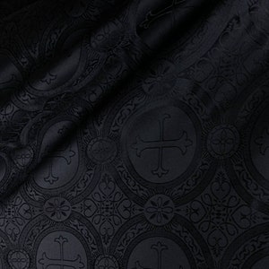 May include: Black fabric with a repeating embossed pattern of crosses and ornate circles.