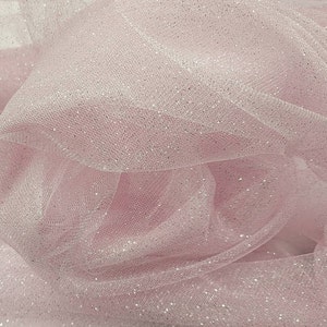 May include: Pink tulle fabric with silver glitter. The fabric is soft and sheer, and the glitter adds a touch of sparkle.