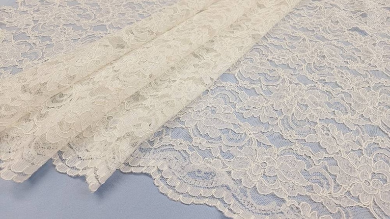 May include: White lace fabric with a delicate floral pattern. The lace is soft and sheer, and it would be perfect for a variety of crafting projects.