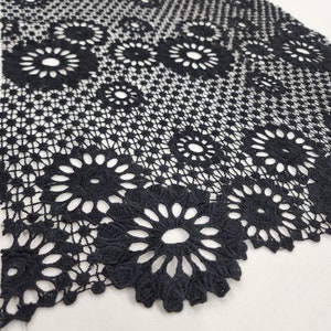 Puede incluir: Tela de encaje negra con un delicado patrón floral. El encaje tiene un borde festoneado y es perfecto para agregar un toque de elegancia a cualquier proyecto.