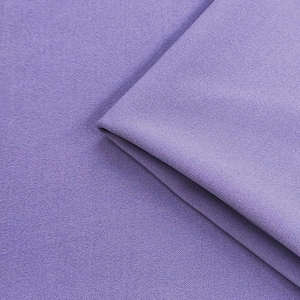 Puede incluir: Primer plano de una tela lavanda doblada. La tela tiene una textura sutil y un acabado suave y mate. Los pliegues crean sombras y añaden profundidad a la imagen, resaltando la caída de la tela.