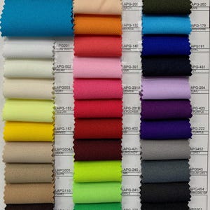 May include: A color chart of fabric swatches with different colors and names. The fabric is 100% polyester and 58/60 inches wide.