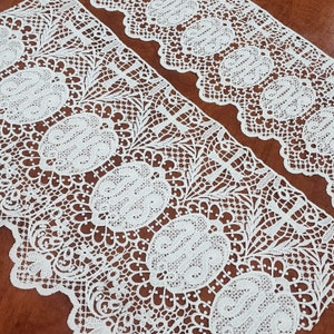 Puede incluir: Borde de encaje blanco con un delicado diseño floral. El encaje tiene un borde festoneado y es perfecto para agregar un toque de elegancia a cualquier proyecto.